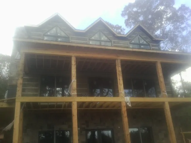 Dormers and porch framing on a large log home under construction in Wolcott